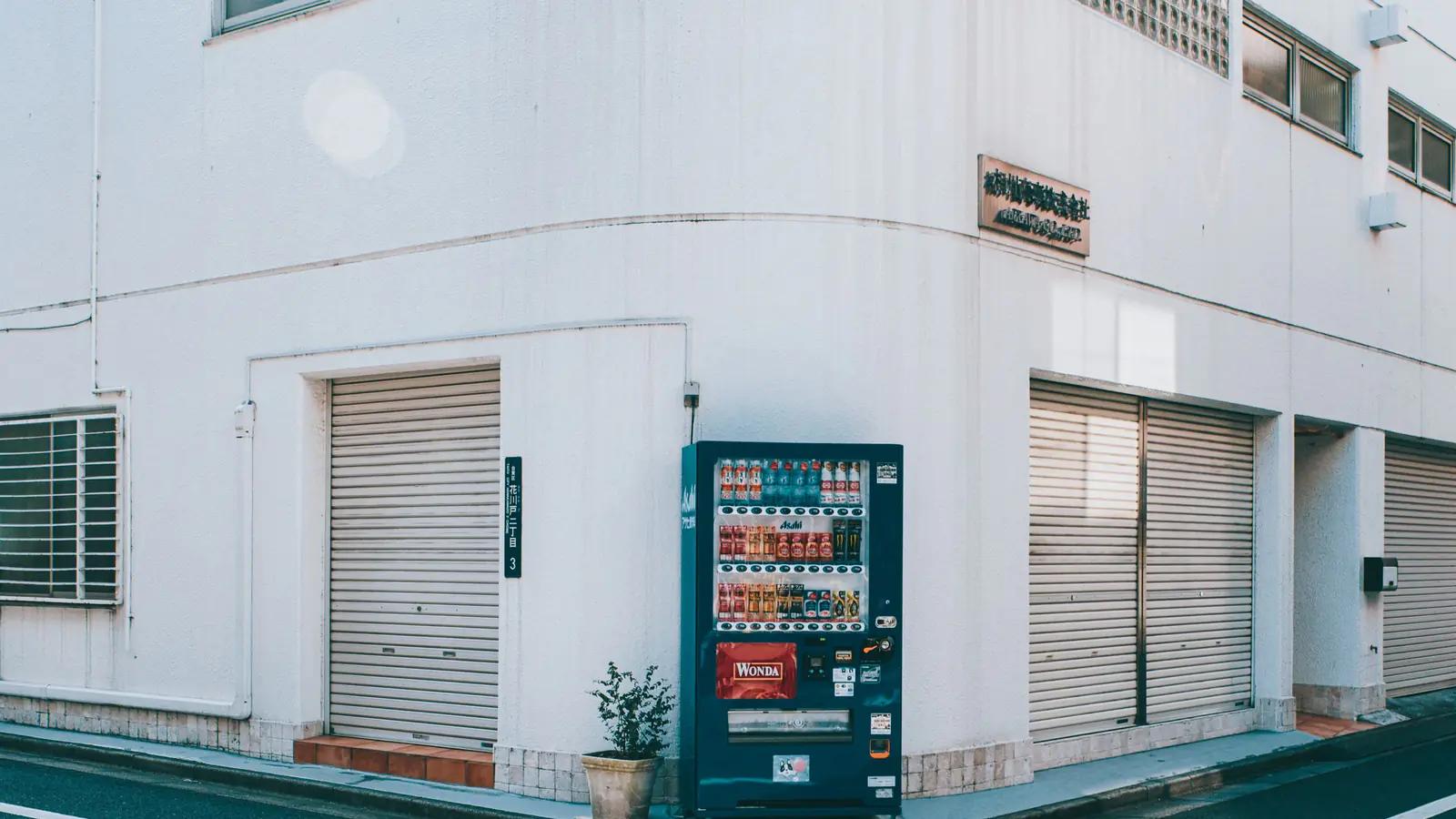 A lone vending machine on a city street corner, the standard product you buy and use as it comes