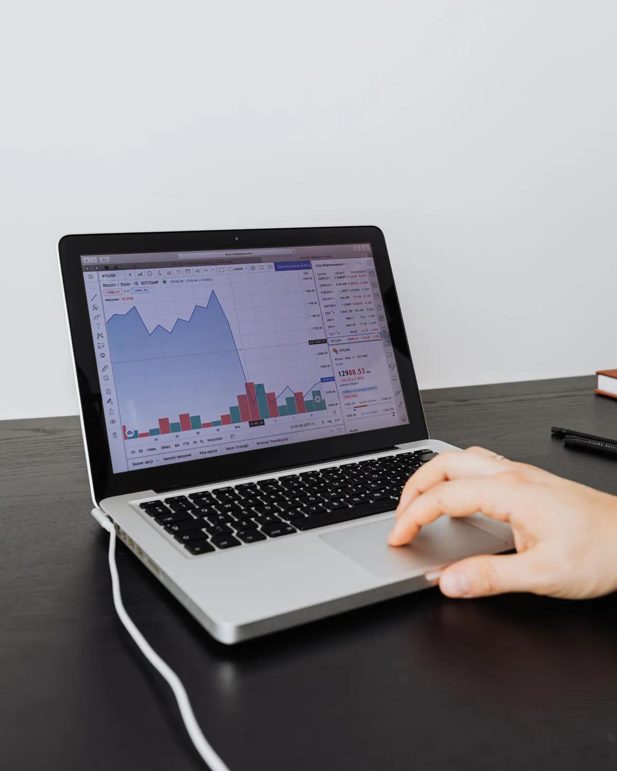 Someone reading performance figures on a laptop, comparing cost per qualified opportunity
